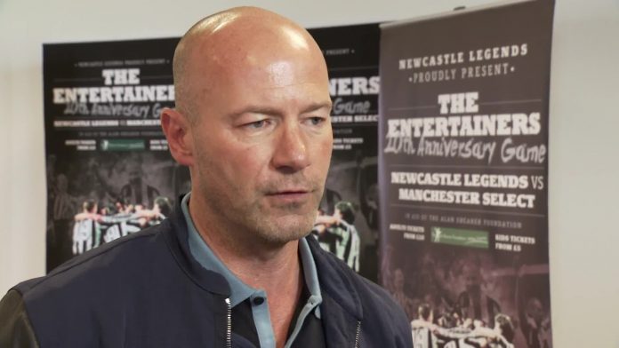 Alan Shearer in front of posters for The Entertainers 20th Anniversary Game